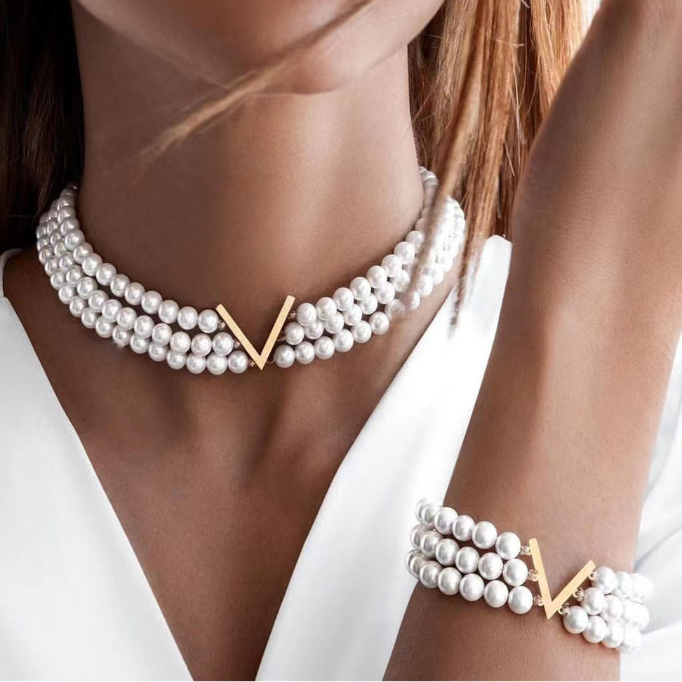 Multi-layered pearl jewelry set for women, featuring a trendy European and American style, with a V-shaped choker, bracelet, necklace, and earring design.