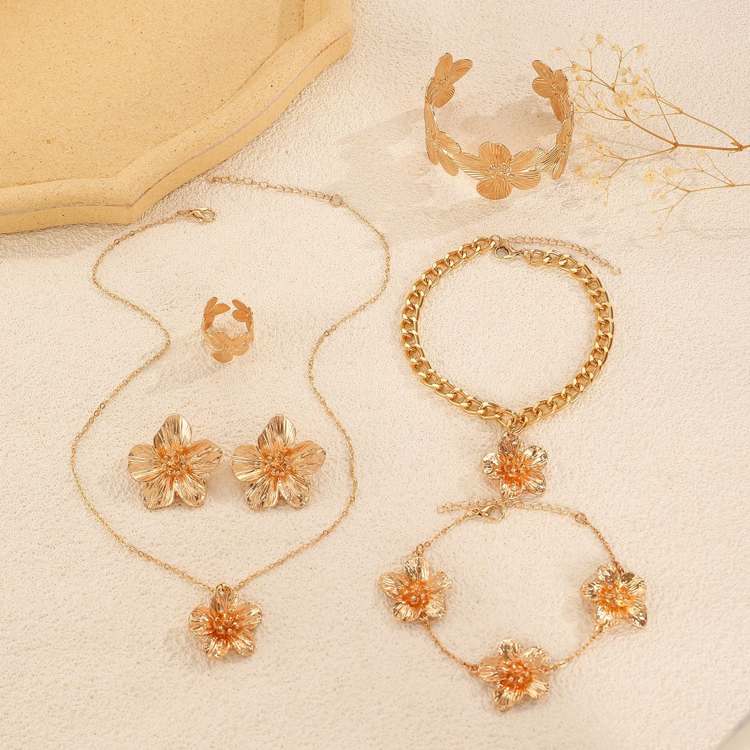 Women's set featuring pleated textured floral earrings, necklace, bracelet, anklet, ring, and bangle.