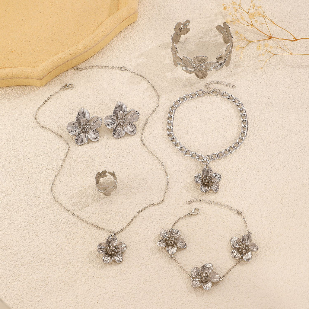 Women's set featuring pleated textured floral earrings, necklace, bracelet, anklet, ring, and bangle.