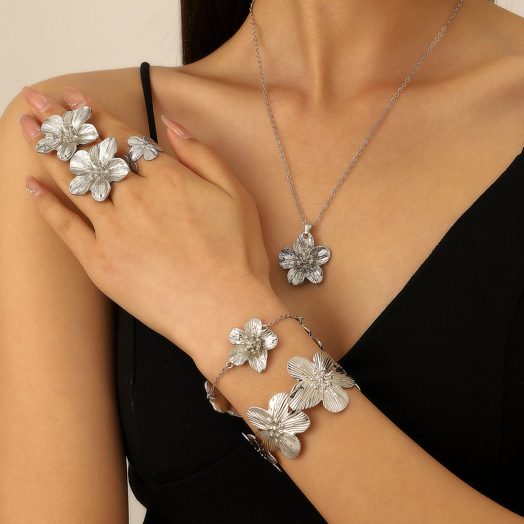 Women's set featuring pleated textured floral earrings, necklace, bracelet, anklet, ring, and bangle.